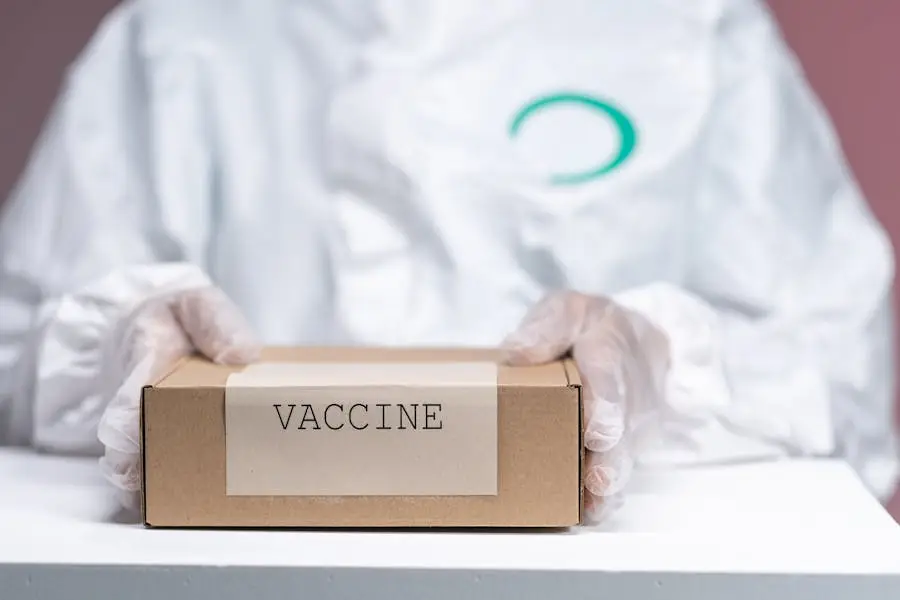Healthcare worker holding a vaccine package in protective gear, emphasizing safety and health.